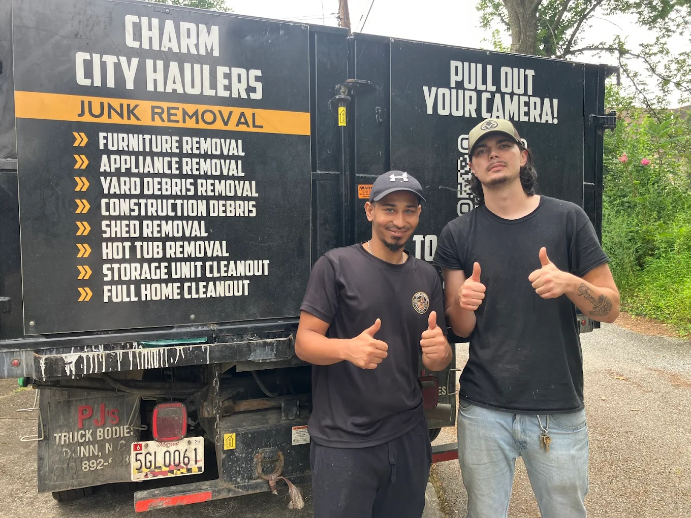 Charm City Haulers crew standing in front of their Junk Removal truck in Baltimore, thumbs up